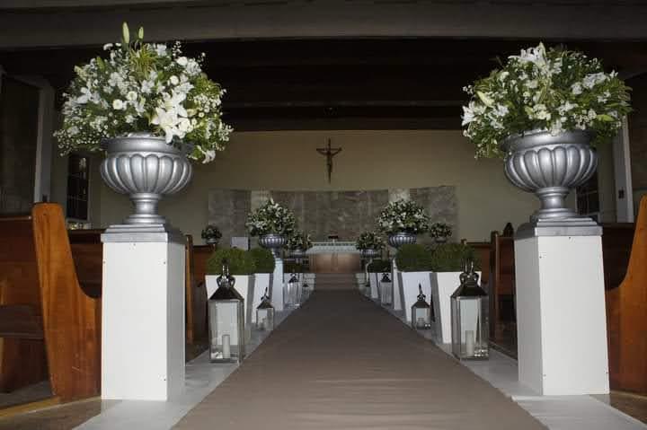 Cerimônia em igreja com vasos prateados e flores brancas