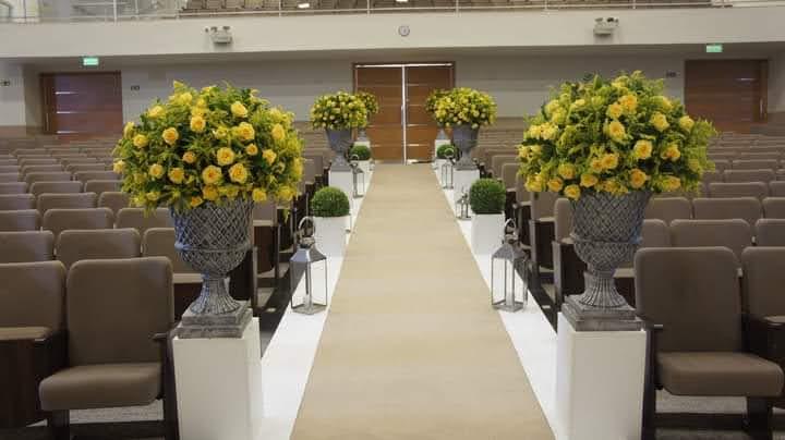Corredor de cerimônia com vasos de flores amarelas e lanternas